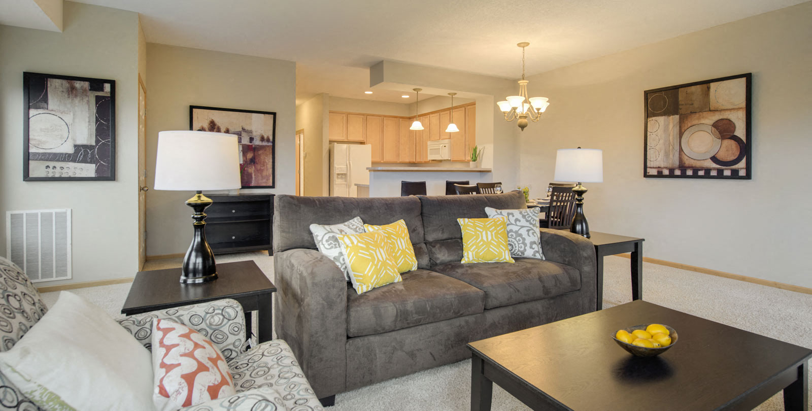 A living room with a grey couch and a black coffee table.