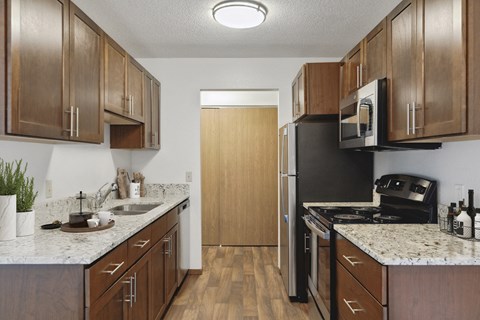 a kitchen with wooden cabinets and a stainless steel refrigerator