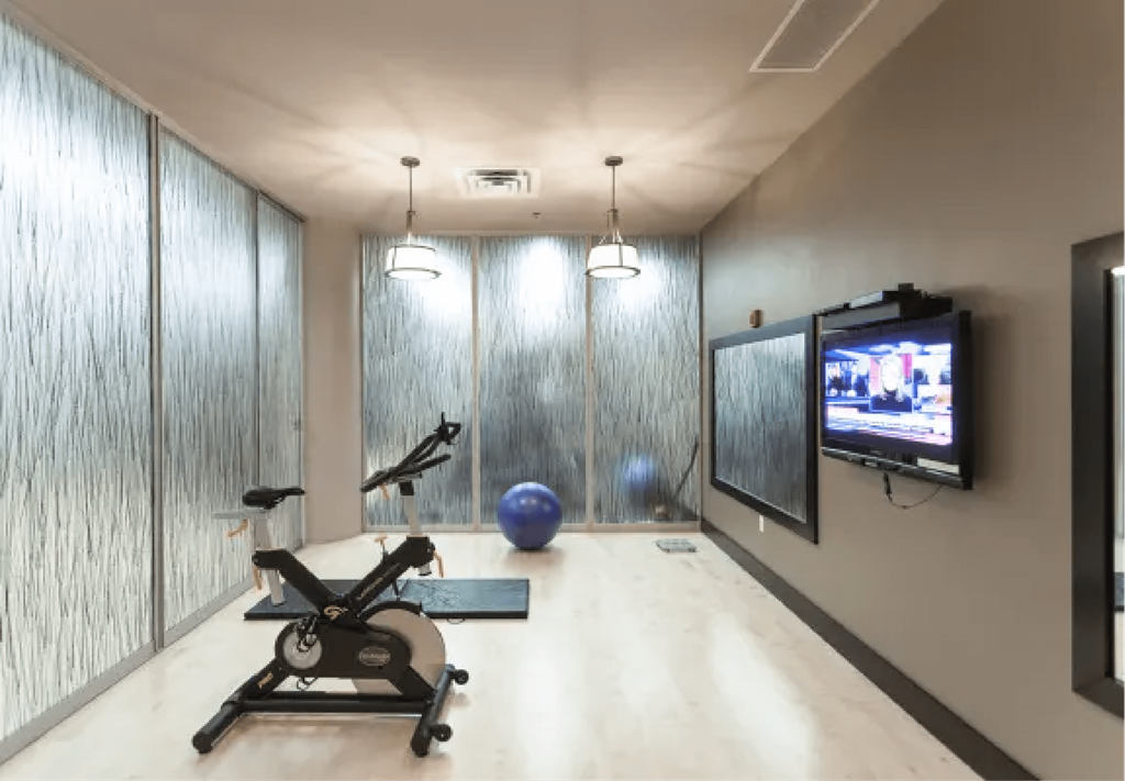 a workout room with a tv and a exercise bike  at The Cosmopolitan, St Paul, Minnesota