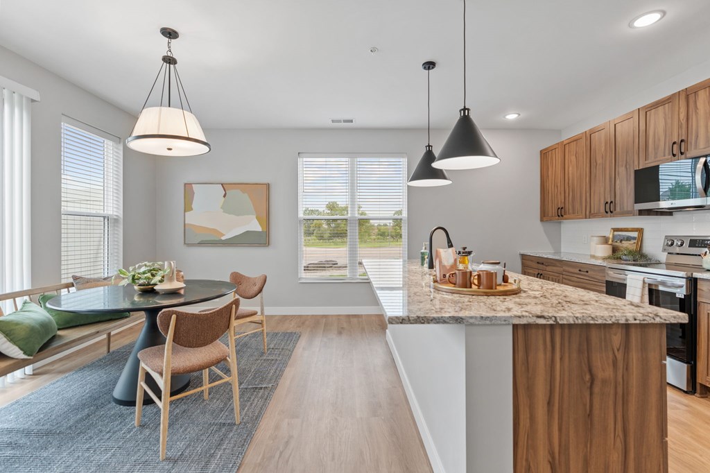 A modern kitchen with a dining table and chairs. at Townhomes at Preserve, Rogers, MN