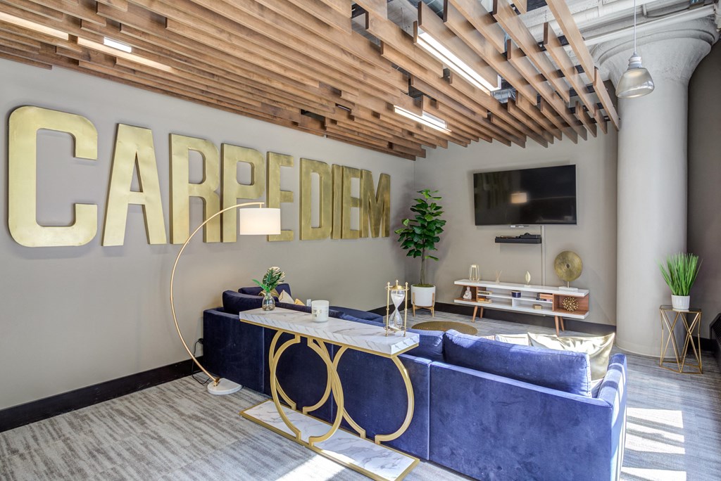 a living room with a couch and a table in front of a sign that reads  at The Cosmopolitan, St Paul