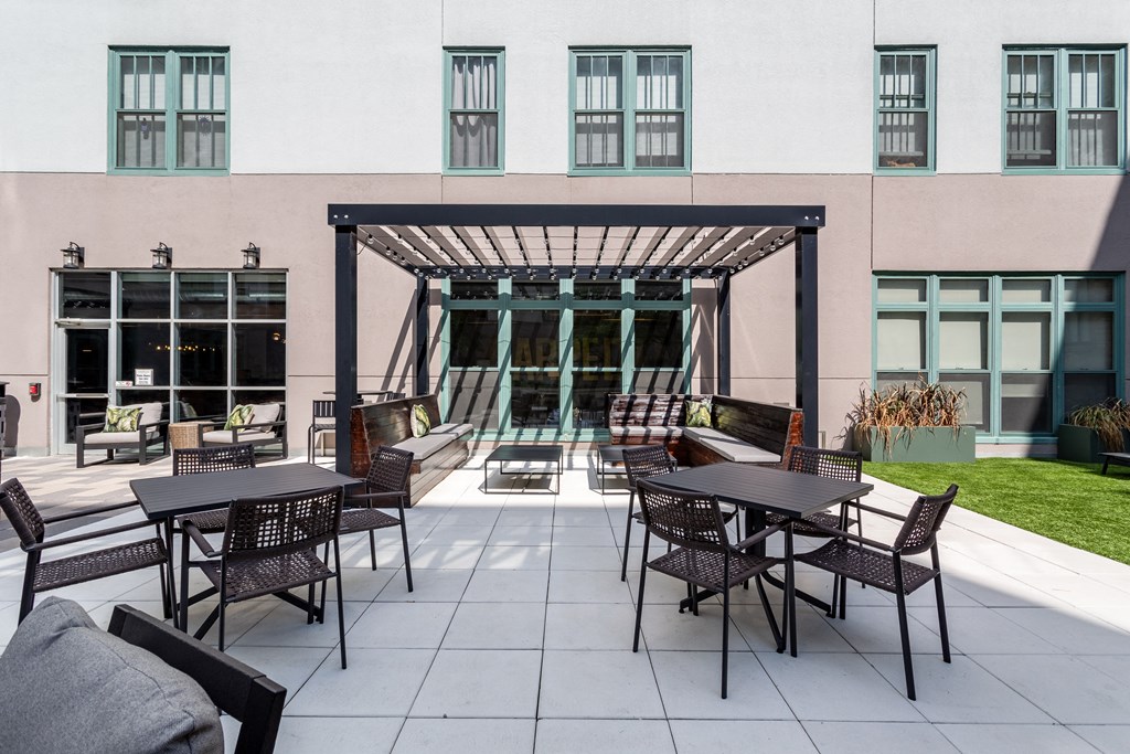 an outdoor patio with tables and chairs and a building in the background  at The Cosmopolitan, St Paul, MN, 55101