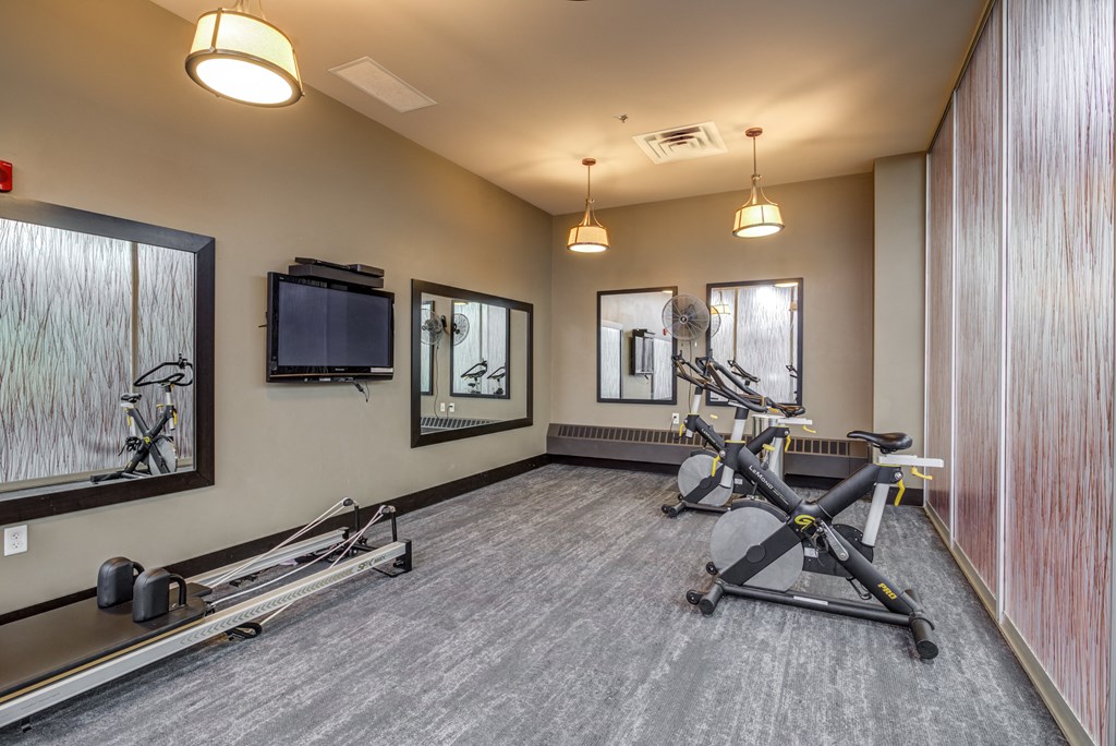 the gym at the landing combines exercise equipment with a tv  at The Cosmopolitan, Minnesota, 55101