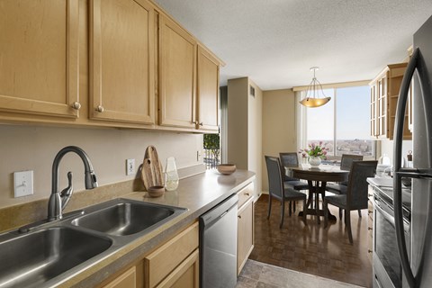 a kitchen with wooden cabinets and a sink and a dining room table