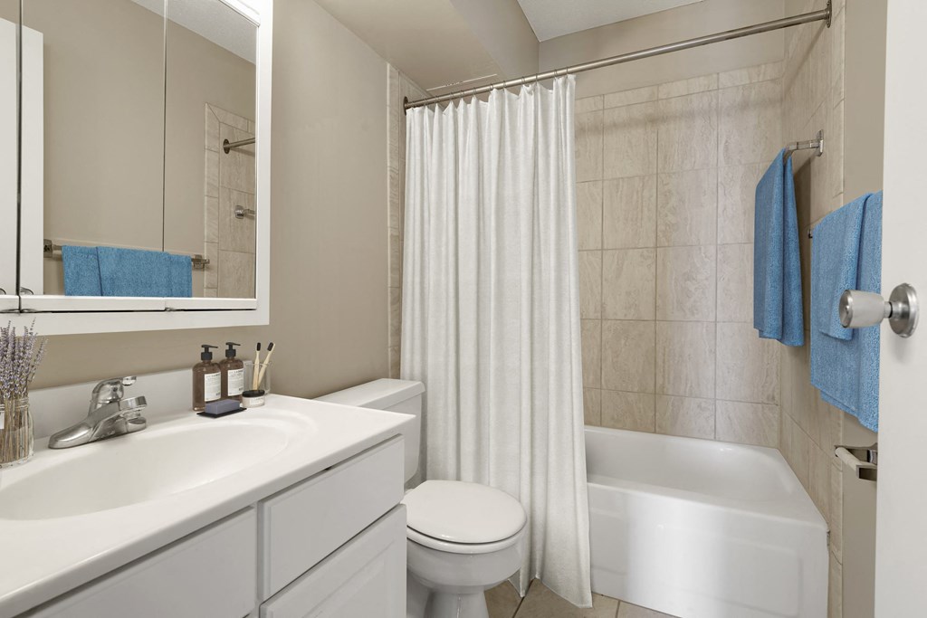 a bathroom with a white bathtub and a white toilet next to a white sink with a at The Edina Towers, Edina