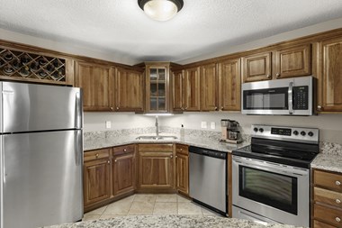 Kitchen with appliances and cabinets at The Riverwood, Lilydale, 55118