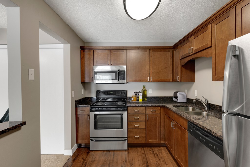 full kitchen with wood cabinets and stainless steel appliances and a window