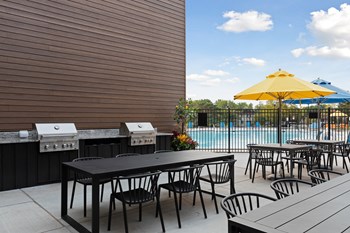 Poolside tables at Villages on McKnight Apartments - Photo Gallery 36