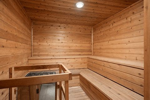 A wooden sauna with a bench and a table.