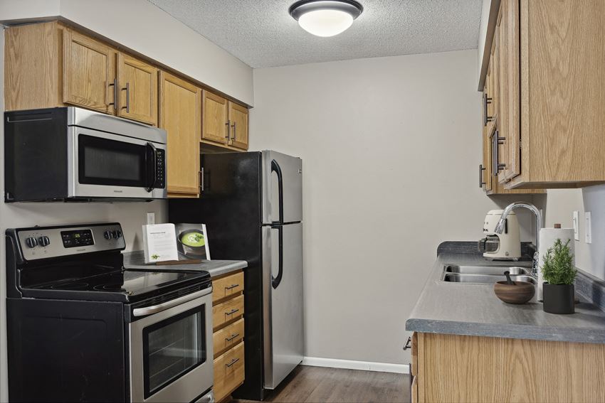 a kitchen with wooden cabinets and stainless steel appliances - Photo Gallery