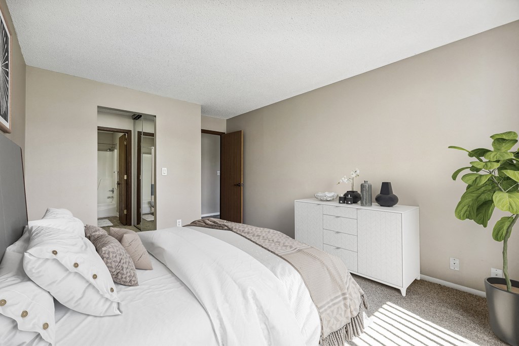 a bedroom with a large white bed and a white dresser  at Willow Creek, Plymouth, Minnesota