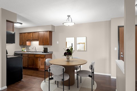 A kitchen with a table and chairs.