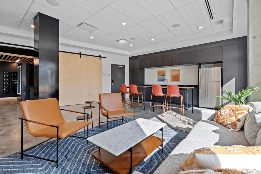 a lounge area with chairs and tables and a kitchen  at Zelia on Seven, St Louis Park, Minnesota