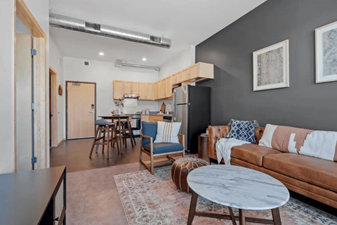 a living room and kitchen with a couch and a table