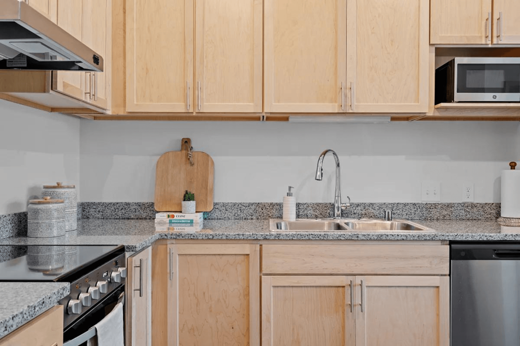 a kitchen with wooden cabinets and granite counter tops at Zelia on Seven, St Louis Park, 55416