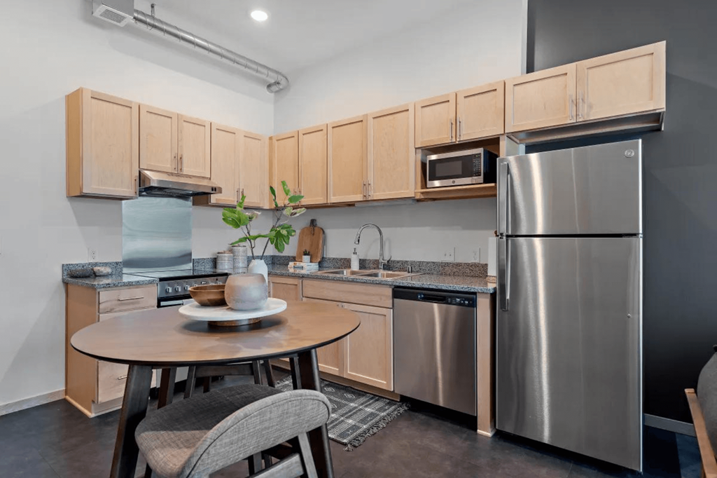 a kitchen with stainless steel appliances and a small table at Zelia on Seven, St Louis Park, Minnesota