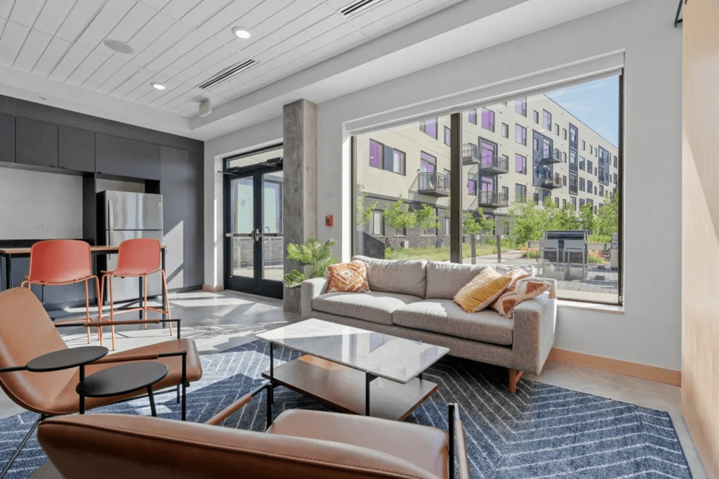 a living room with a couch and chairs and a large window at Zelia on Seven, Minnesota