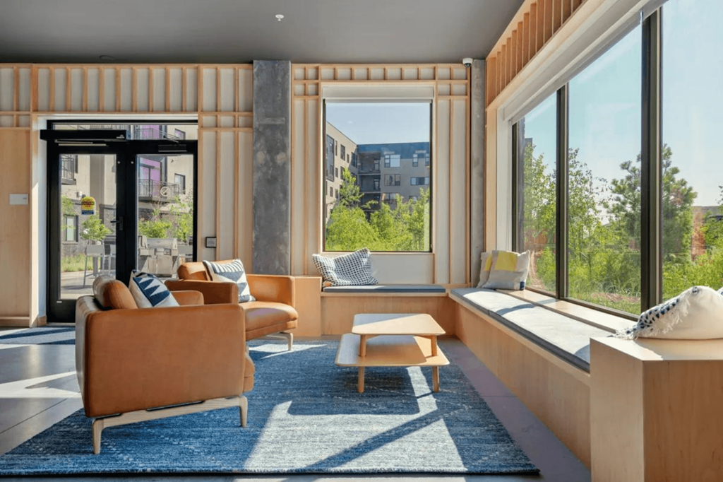 a living room with a couch and a table in front of a window  at Zelia on Seven, St Louis Park