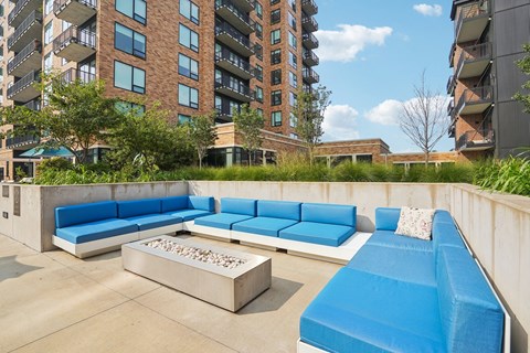 A blue couch is on a patio with a fire pit at Expo Minneapolis