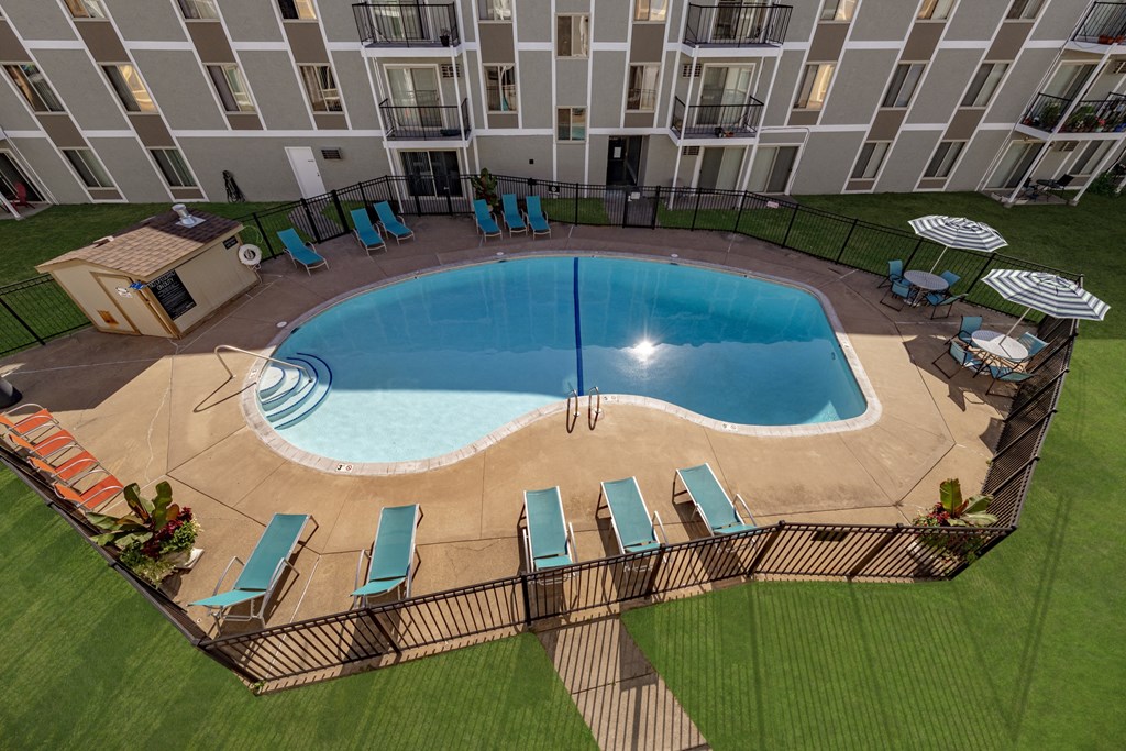 an aerial view of an apartment building with an oval swimming pool
