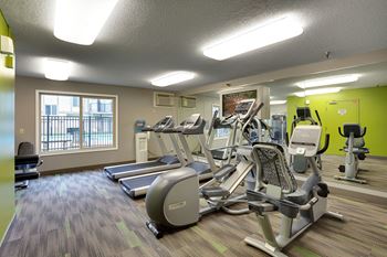 A gym with treadmills, exercise bikes and other equipment.