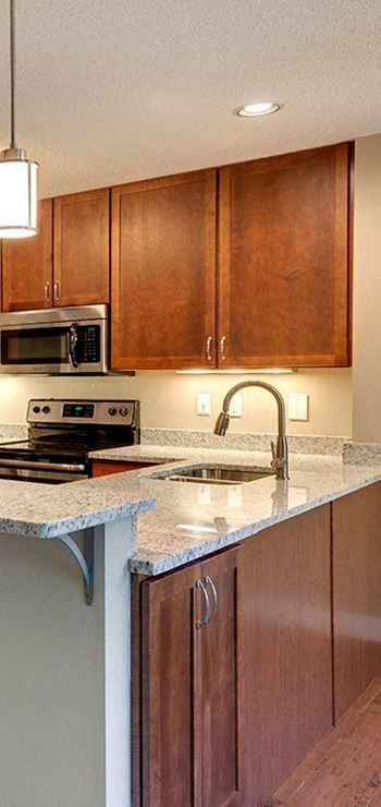 A kitchen with brown cabinets and a white counter top.