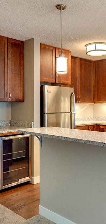 A kitchen with a refrigerator and wooden cabinets.
