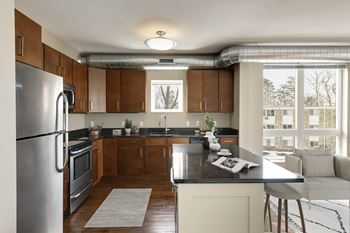 A modern kitchen with a refrigerator, sink, and a dining area.