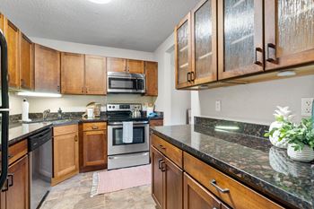 A kitchen with wooden cabinets and granite countertops.