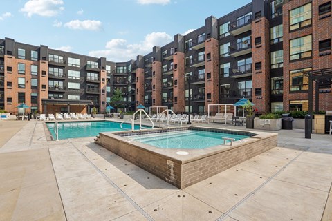 A large outdoor swimming pool surrounded by apartment buildings.