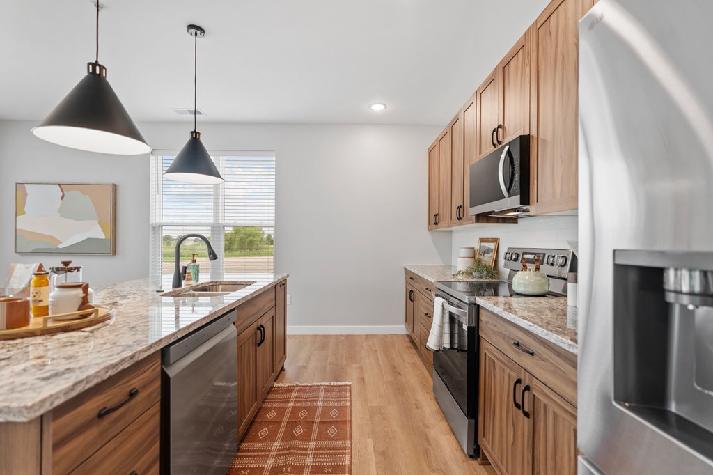 A kitchen with wooden cabinets and a granite countertop. at Townhomes at Preserve, Rogers, 55374