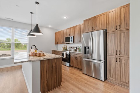 A modern kitchen with wooden cabinets and a marble countertop.