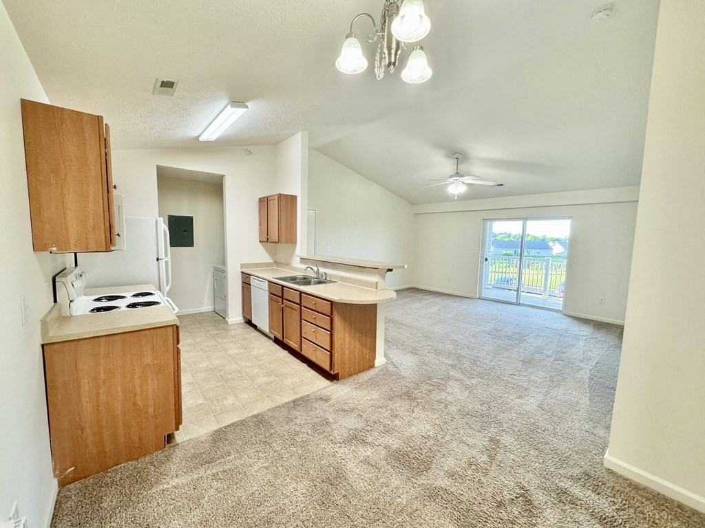 an empty living room with an empty kitchen and a large window at Hawthorne Properties in Lafayette, IN 47905