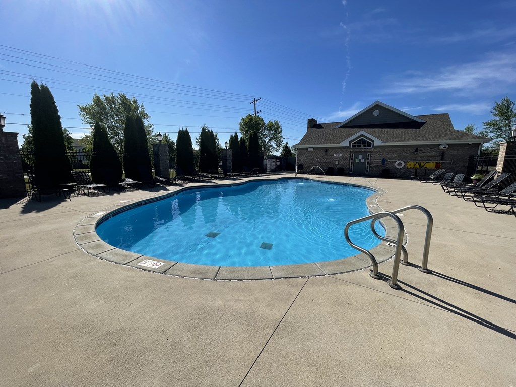 a resort style pool with chairs around it and a house in the background at Hawthorne Properties in Lafayette, IN 47905