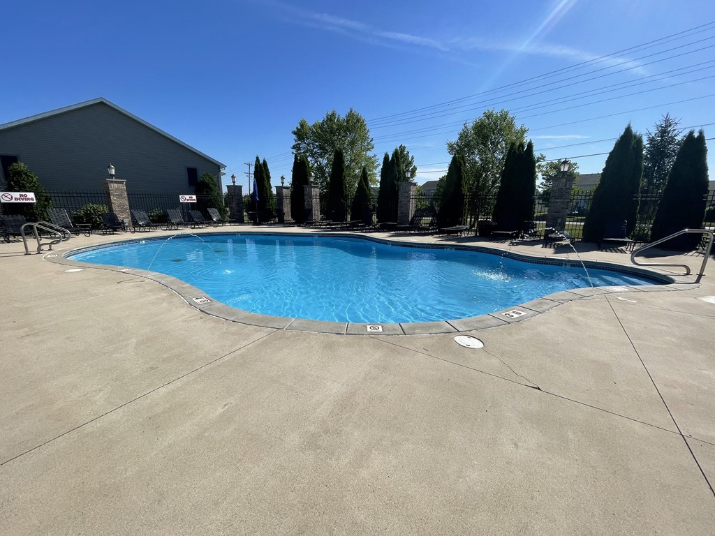 a resort style pool is shown in front of a building with trees at Hawthorne Properties in Lafayette, IN 47905