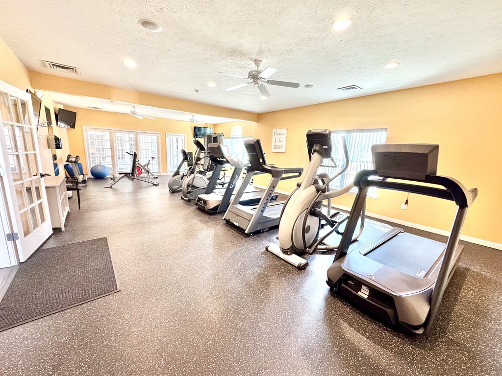A gym with treadmills, elliptical machines, and other exercise equipment.