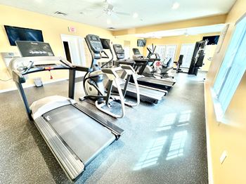 A gym with treadmills, elliptical machines, and other exercise equipment.