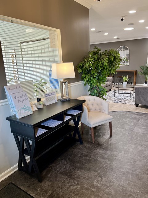 A reception desk with a white chair and a sign that reads "Shamrock Proposal" in front of a window with blinds.