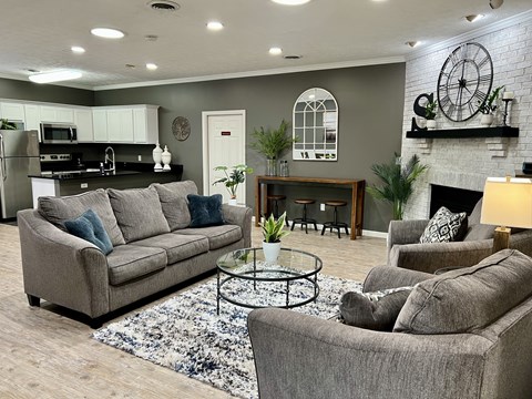 A living room with grey couches and a fireplace.