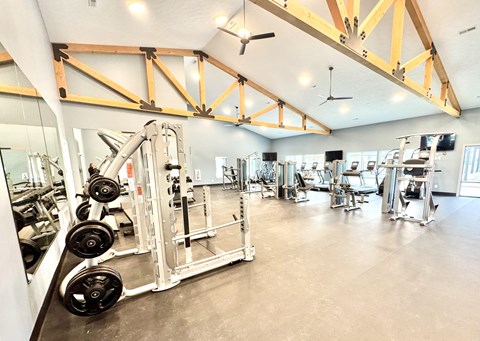 A gym with a variety of equipment including a weight rack and a squat rack.at Concord Crossing, Lafayette Indiana  