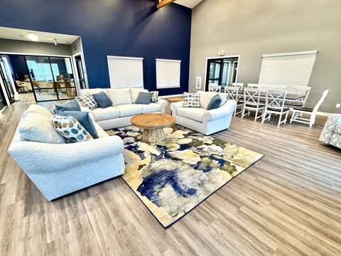 A living room with a blue couch and a rug.