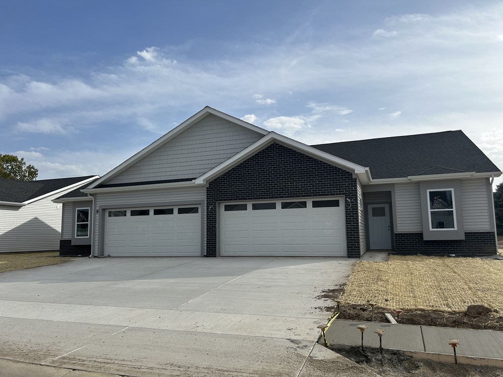 a white house with a driveway and a garage door at Concord Crossing, Lafayette, IN 47909