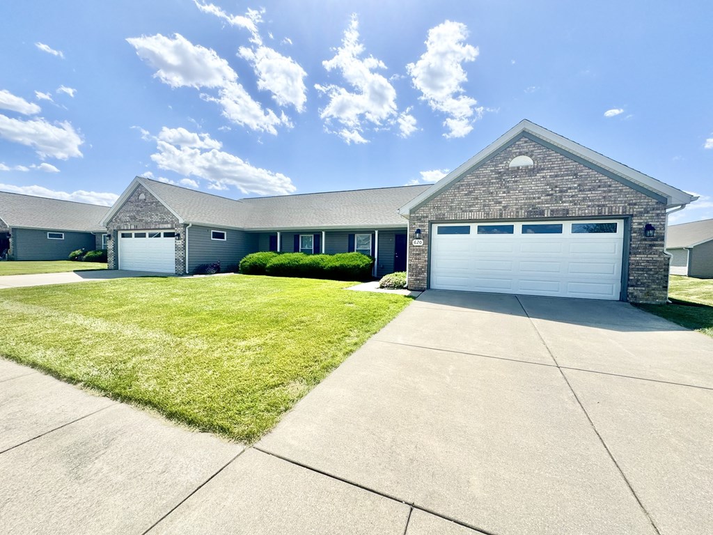 a house with a white garage door and a lawn at Hawthorne Properties in Lafayette, IN 47905
