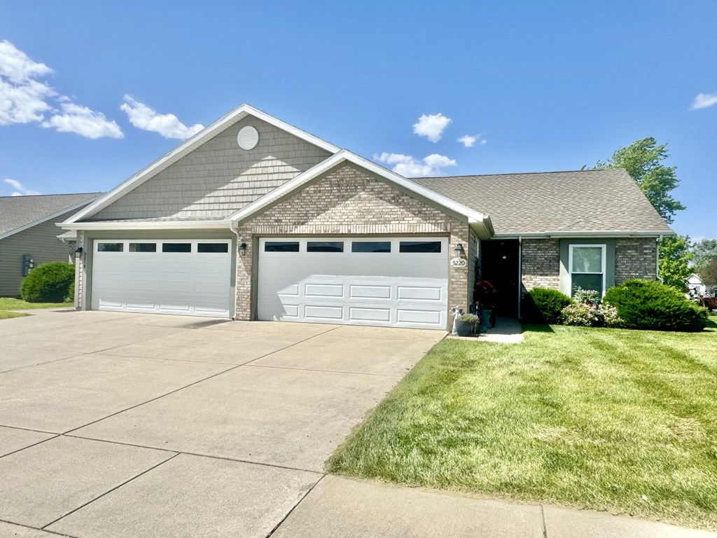 a brick house with a white garage door and a driveway at Hawthorne Properties in Lafayette, IN 47905
