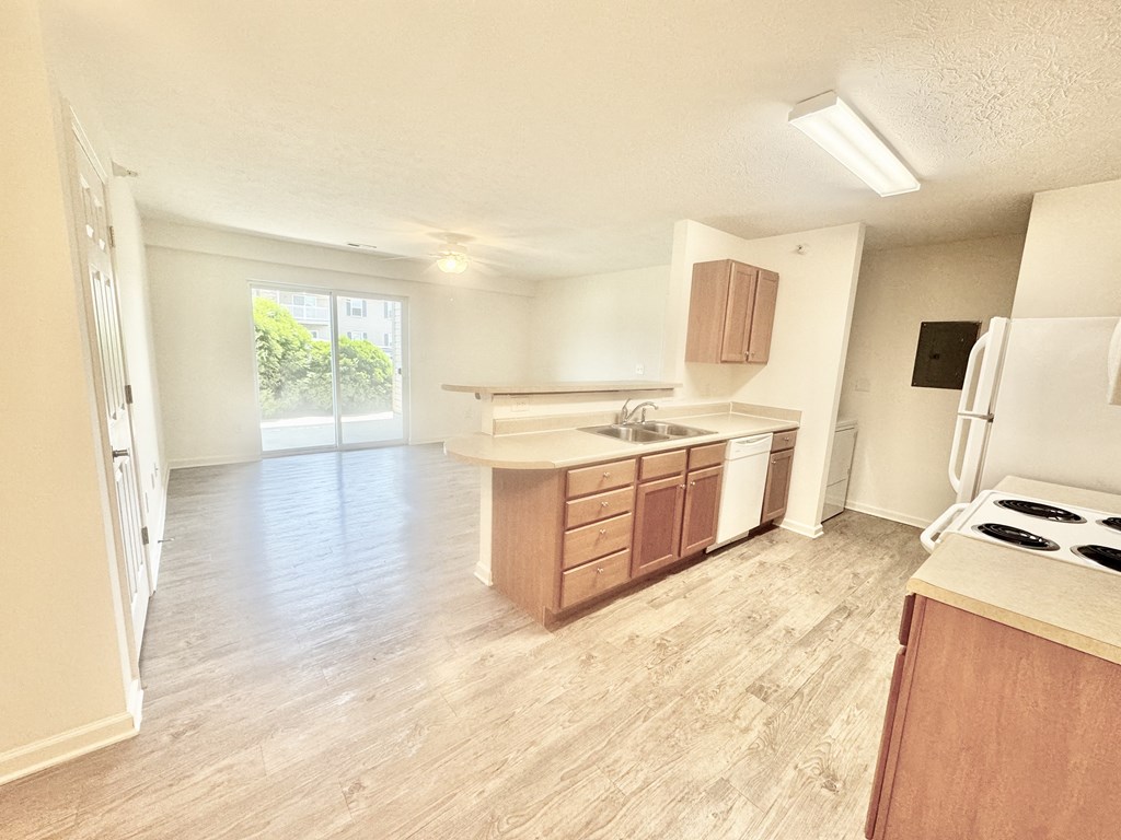 an empty kitchen and living room with wood flooring at Hawthorne Properties in Lafayette, IN 47905