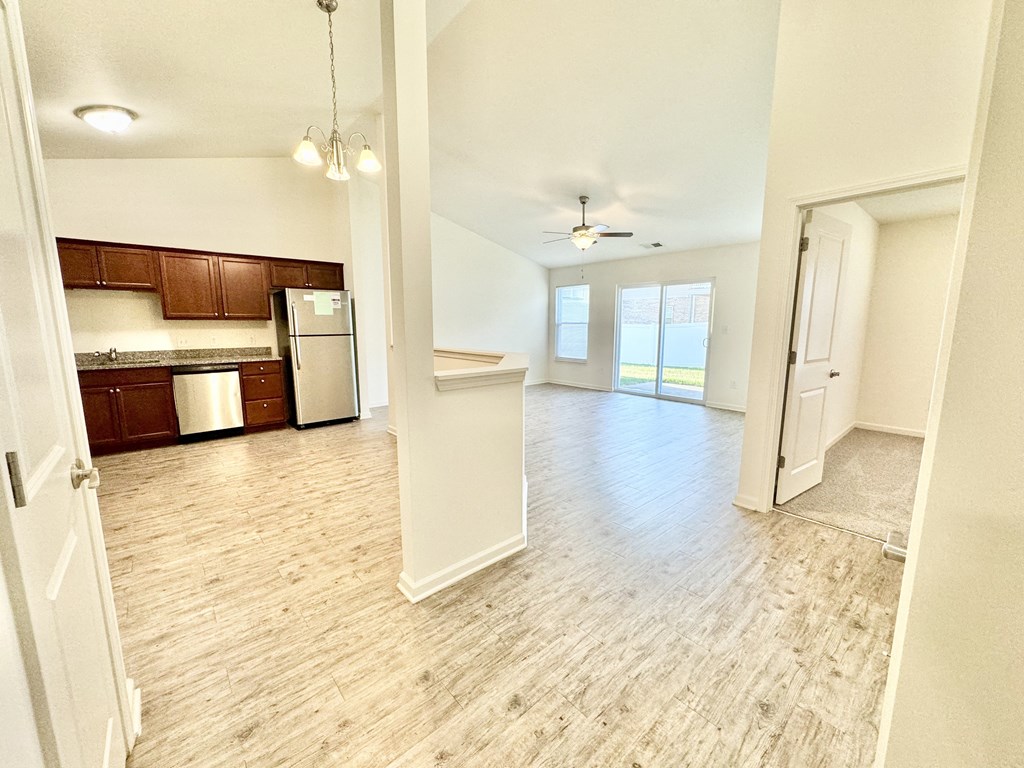an empty living room and kitchen with a wood floor at Hawthorne Properties in Lafayette, IN 47905