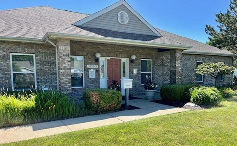 a brick building with a red door and a sign in front of it at Shenandoah Properties in Lafayette, IN 47905