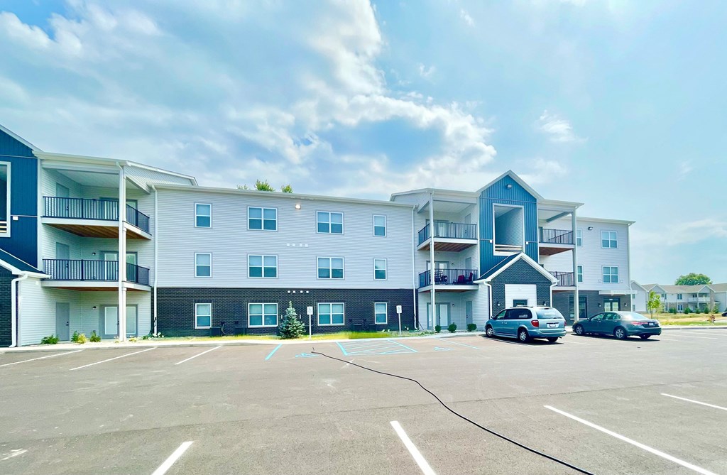 a parking lot with cars in front of a building at Murdock Gardens Apartments, Lafayette, IN 47904