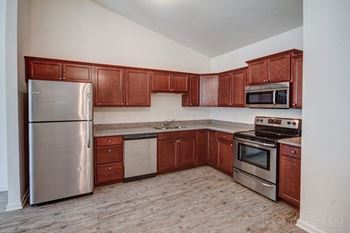 a kitchen with wooden cabinets and stainless steel appliances at Concord Crossing, Lafayette, IN 47909