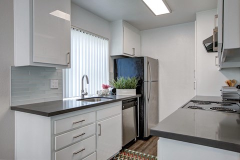 a kitchen with white cabinets and a stainless steel refrigerator